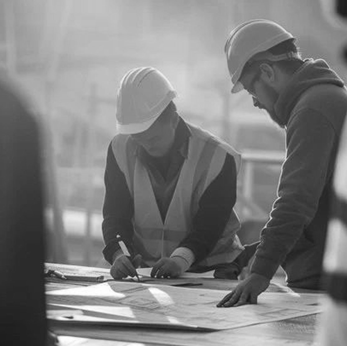 Deux techniciens étudiant des plans sur un chantier